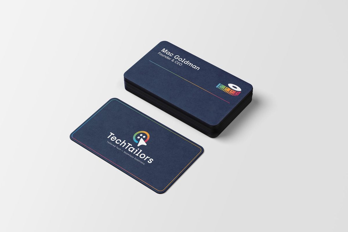A stack of navy TechTailors business cards with Mac Goldman's name, the gradient rule and the tape mark, beside a card showing the button-mark logo.